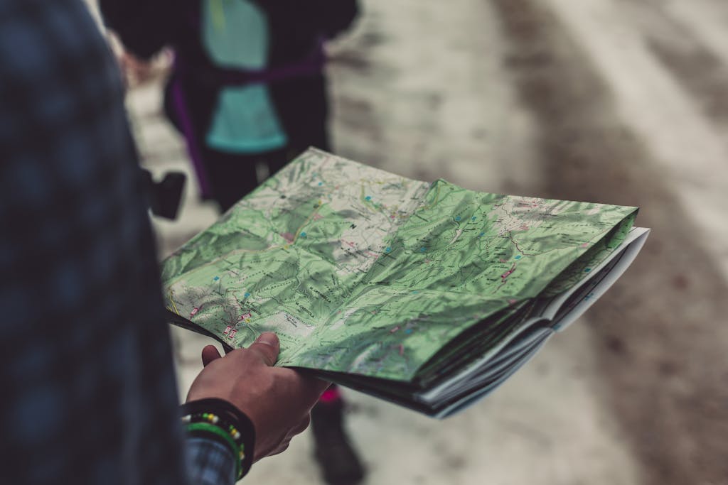 A close-up of a person holding a detailed route map outdoors, ideal for travel and exploration themes.